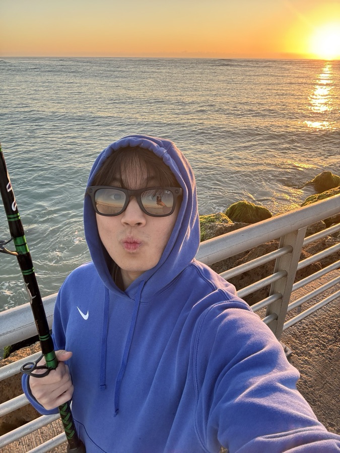 Fishing off a pier at sunset